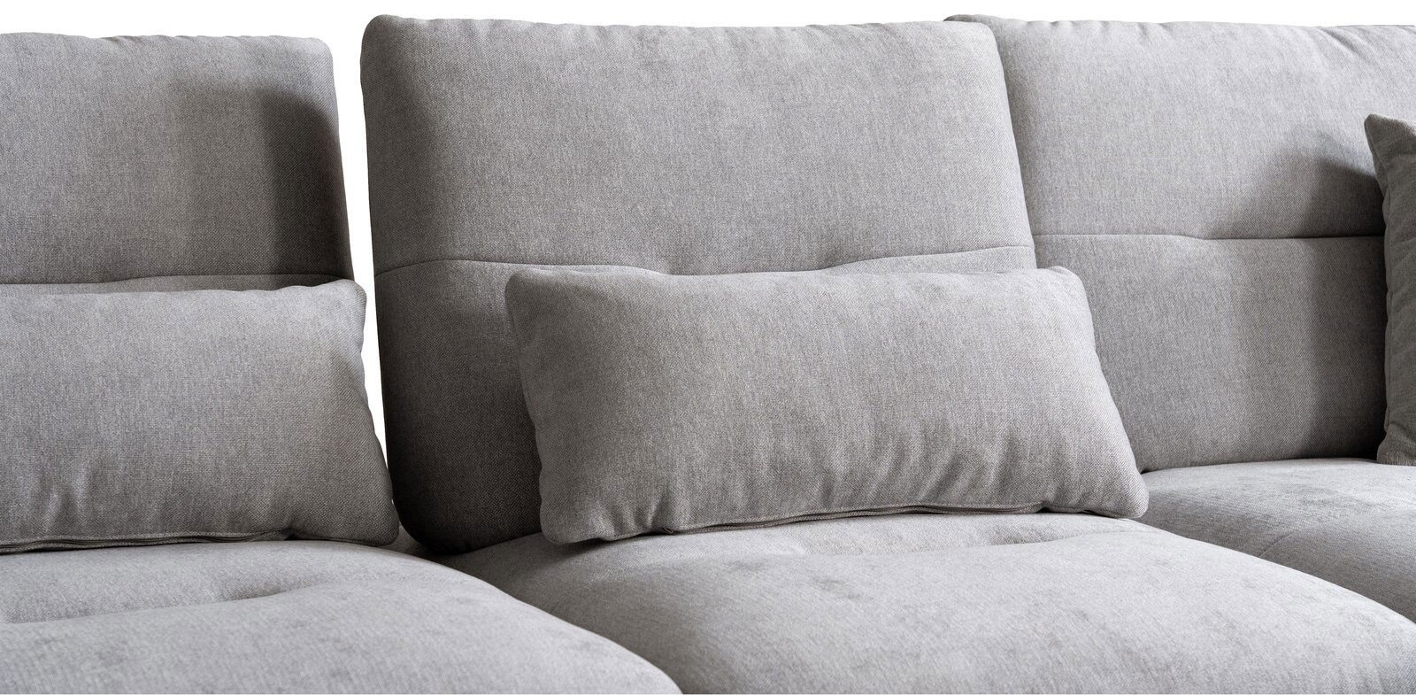 Graues Sofa mit weichen Kissen, Nahaufnahme der Rückenlehne und Sitzfläche, seitliche Perspektive