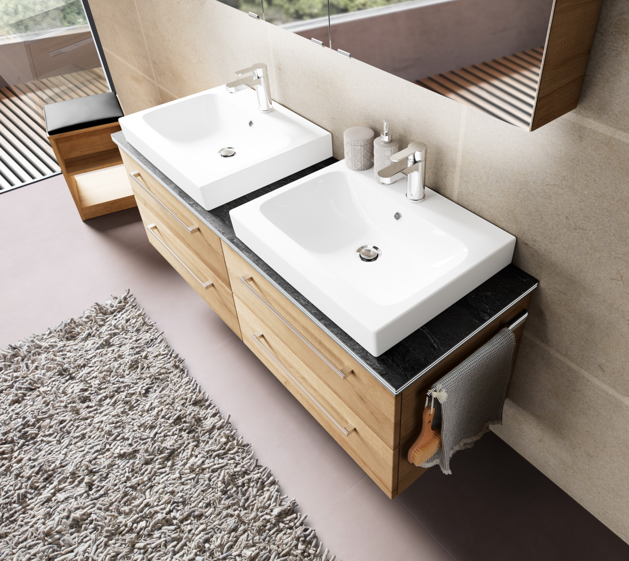 Moderne Badkombination mit zwei weißen Waschbecken auf einer dunklen Arbeitsplatte, Holzunterschränken und seitlichem Handtuchhalter, aus der Vogelperspektive.