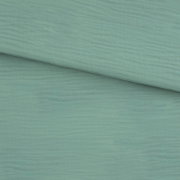 Nahaufnahme einer mintgrünen Holzoptik-Oberfläche mit feiner Maserung, schräg von oben fotografiert; zwei Paneele/Platten überlappen sich diagonal.