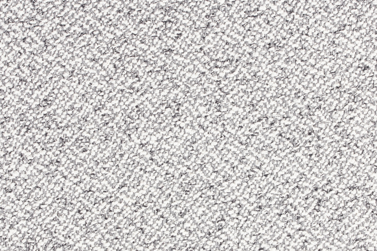 Nahaufnahme der grauen, strukturierten Stoffoberfläche des Hockers MILOU.