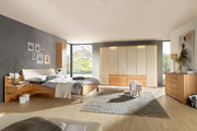 Moderner Schlafzimmerblick mit Dieter Knoll Gleittüren-Funktionsschrank AMATO in Holzoptik, umgeben von stilvollen Möbeln und natürlichem Licht.