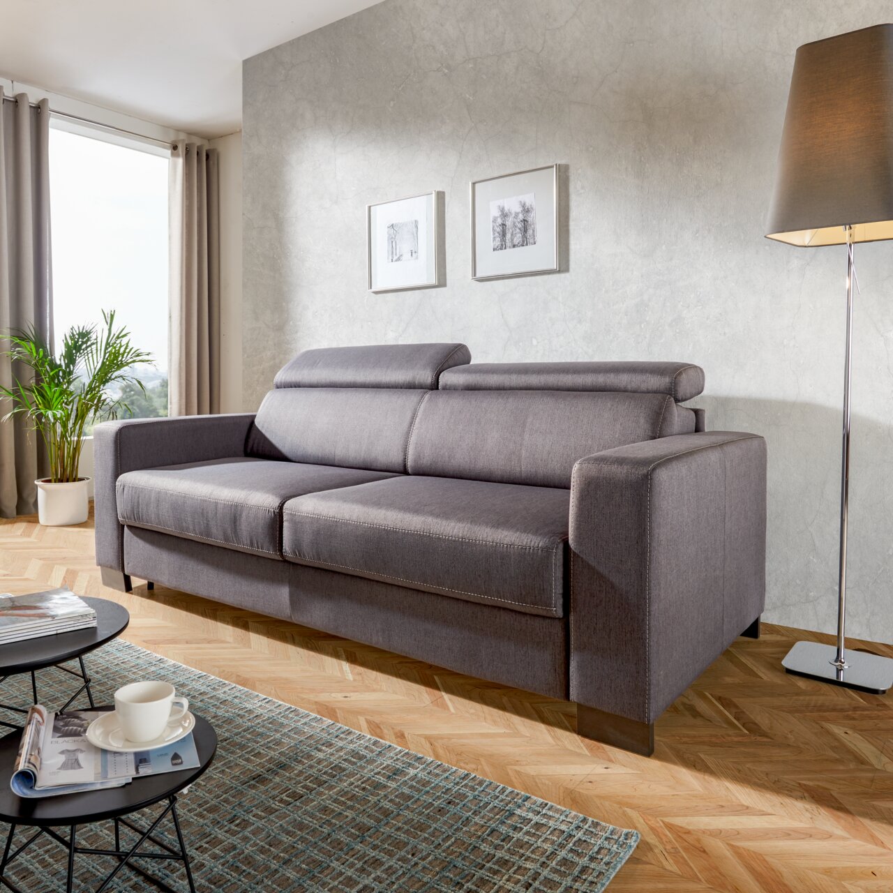 Novel Schlafsofa ARIELLA Graues Funktionssofa in modernem Wohnzimmer, seitliche Perspektive