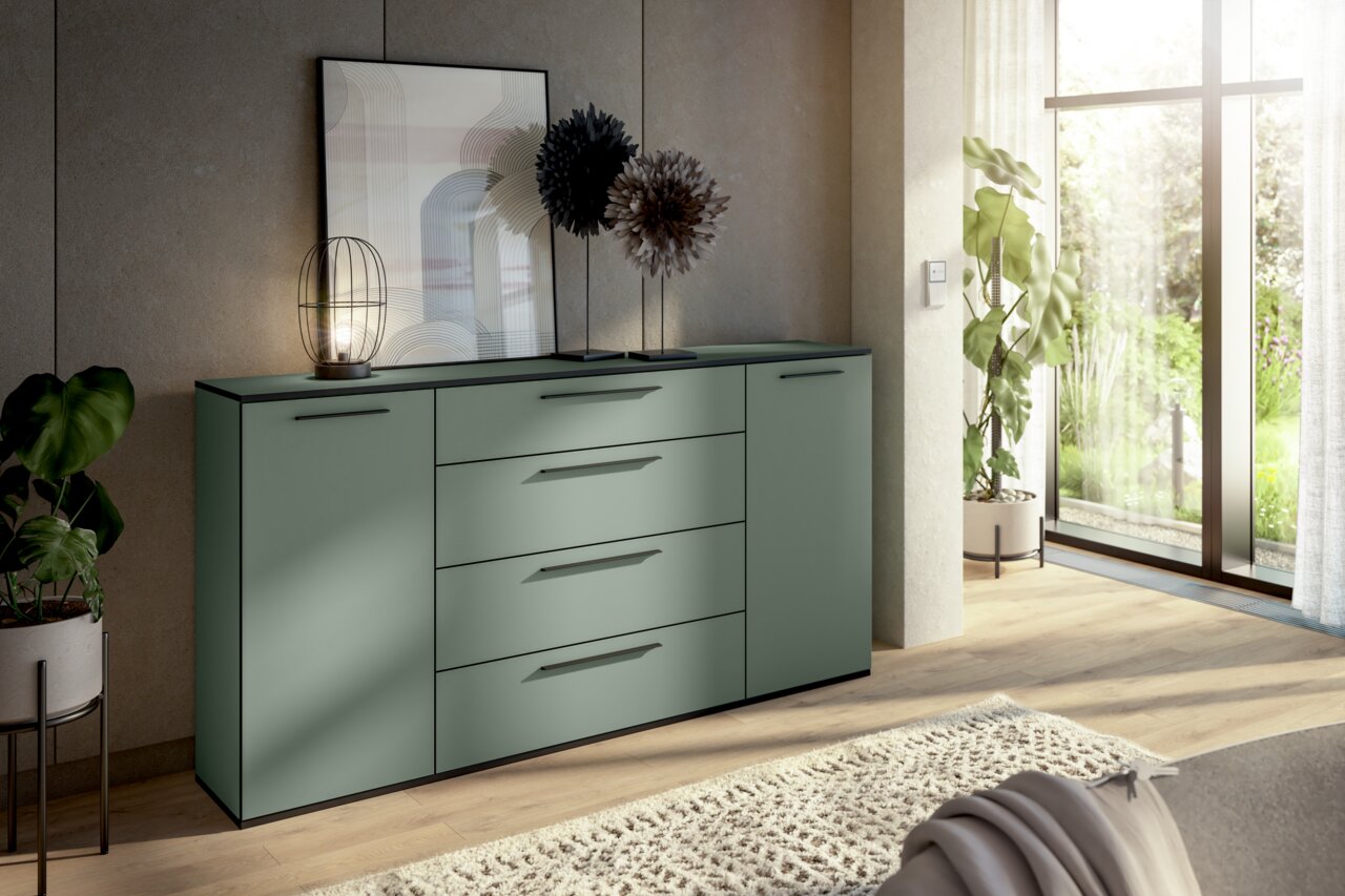 Modernes Sideboard in einem hellen Raum mit Pflanzen und großen Fenstern, seitliche Perspektive