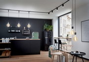 Moderne Küche mit schwarzen Hängelampen und minimalistischer Einrichtung, seitliche Perspektive