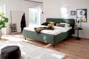 Modern gestoffeerd bed in een stijlvolle slaapkamer, zijaanzicht