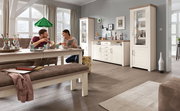 Gemütliches Esszimmer mit Esstisch, Bank und Vitrine in heller Holzoptik, seitliche Perspektive.