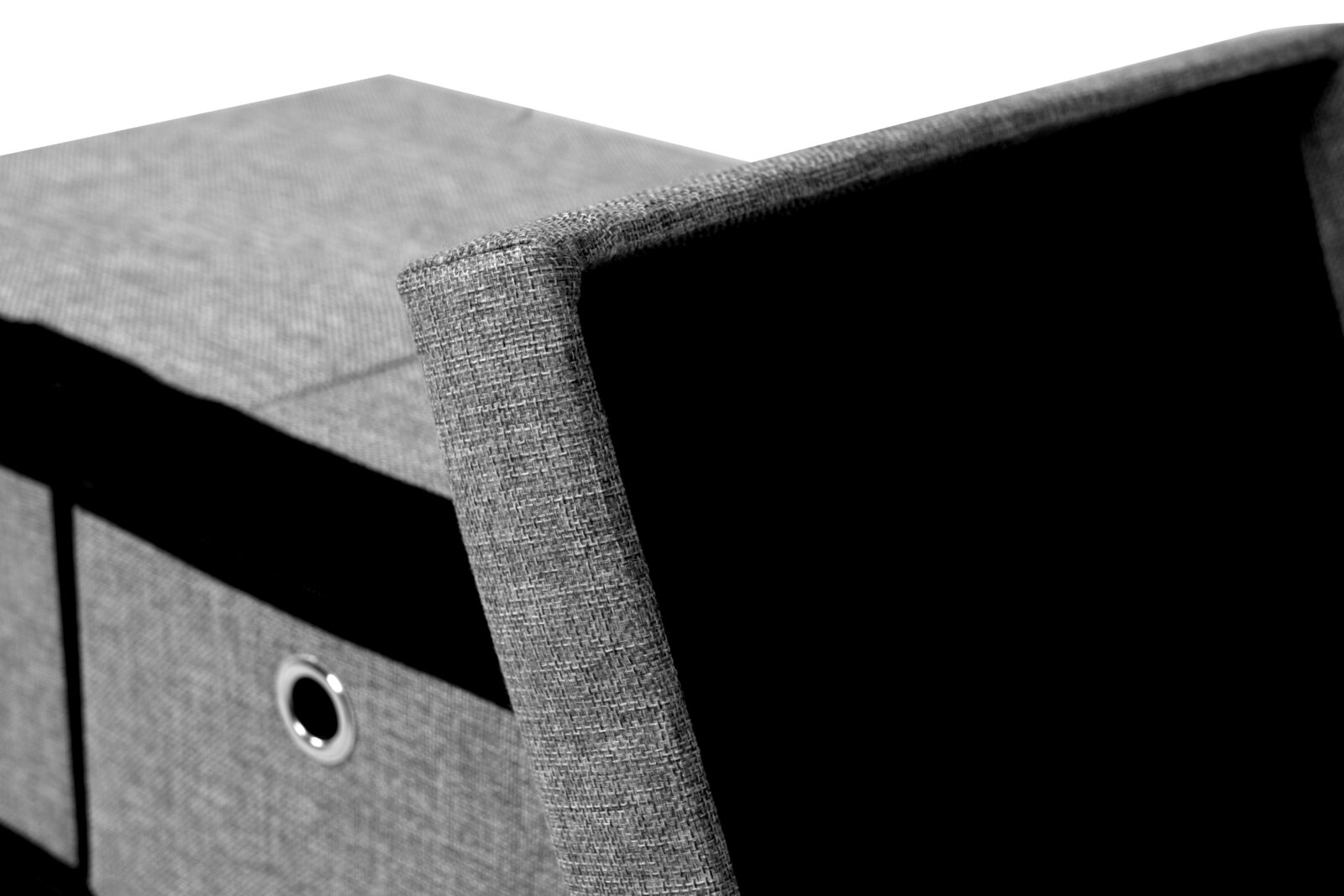Close-up van een grijze bank met opbergruimte, gefotografeerd van bovenaf. Het deksel staat gedeeltelijk open en laat de zwarte binnenkant zien.