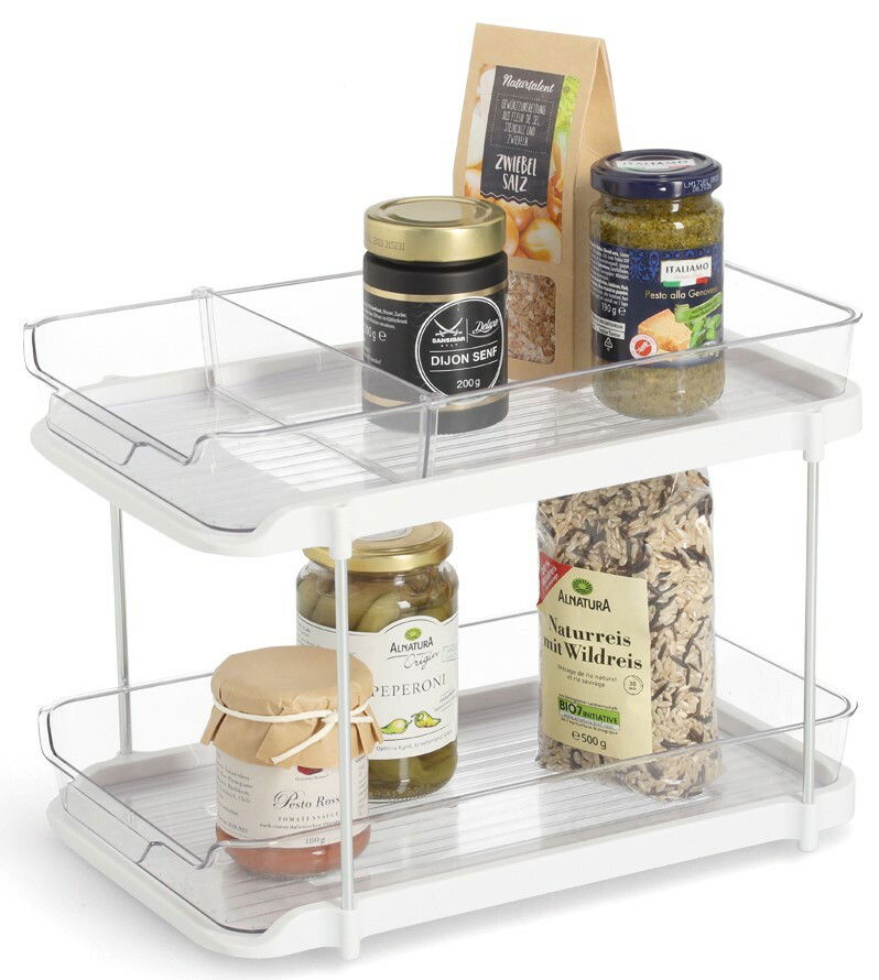Zweistöckiges Etagenregal aus weißem Metall mit transparenten Seiten, gefüllt mit verschiedenen Lebensmitteln in Gläsern und Verpackungen, seitliche Perspektive.