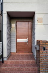 Moderne Akku-Wandleuchte neben einer Eingangstür, frontal betrachtet