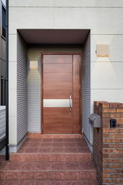 Moderne Akku-Wandleuchte neben einer Eingangstür, frontal betrachtet