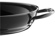 Nahaufnahme einer schwarzen Servierpfanne mit glänzender Oberfläche und einem stabilen Griff, seitliche Perspektive.