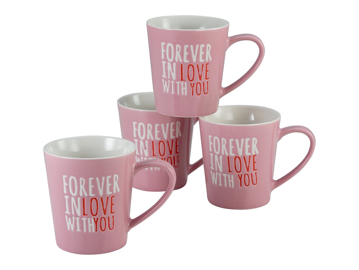 creaTable Kaffeebecher 4-tlg LOVE COLLECTION Vier rosafarbene Keramikbecher mit weißem Innenraum und Aufdruck „FOREVER IN LOVE WITH YOU“ in Weiß und Rot, schräg von vorne in leicht erhöhter Perspektive fotografiert.