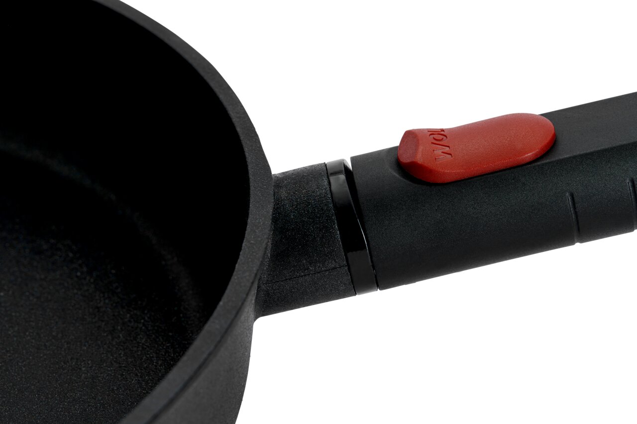 Nahaufnahme einer Gusspfanne Eco Logic 20cm QXR mit schwarzem Griff und rotem Knopf, seitliche Perspektive.