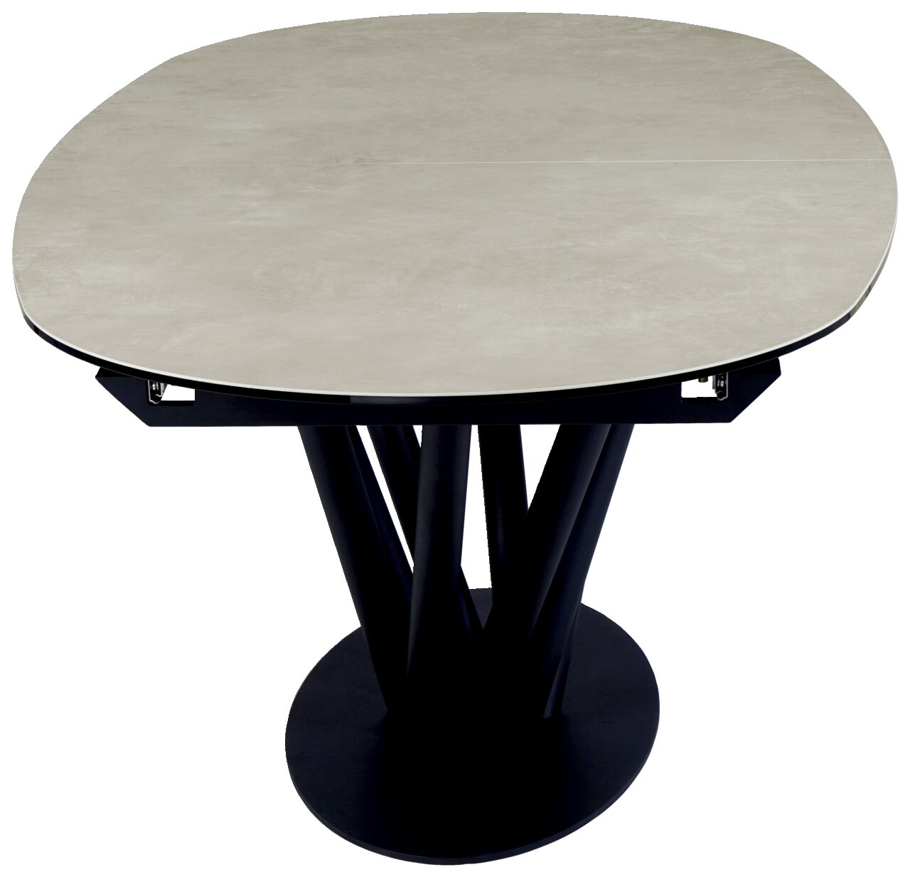 Moderne eettafel met een rond, licht blad en een zwart, sculpturaal onderstel, gezien van bovenaf.