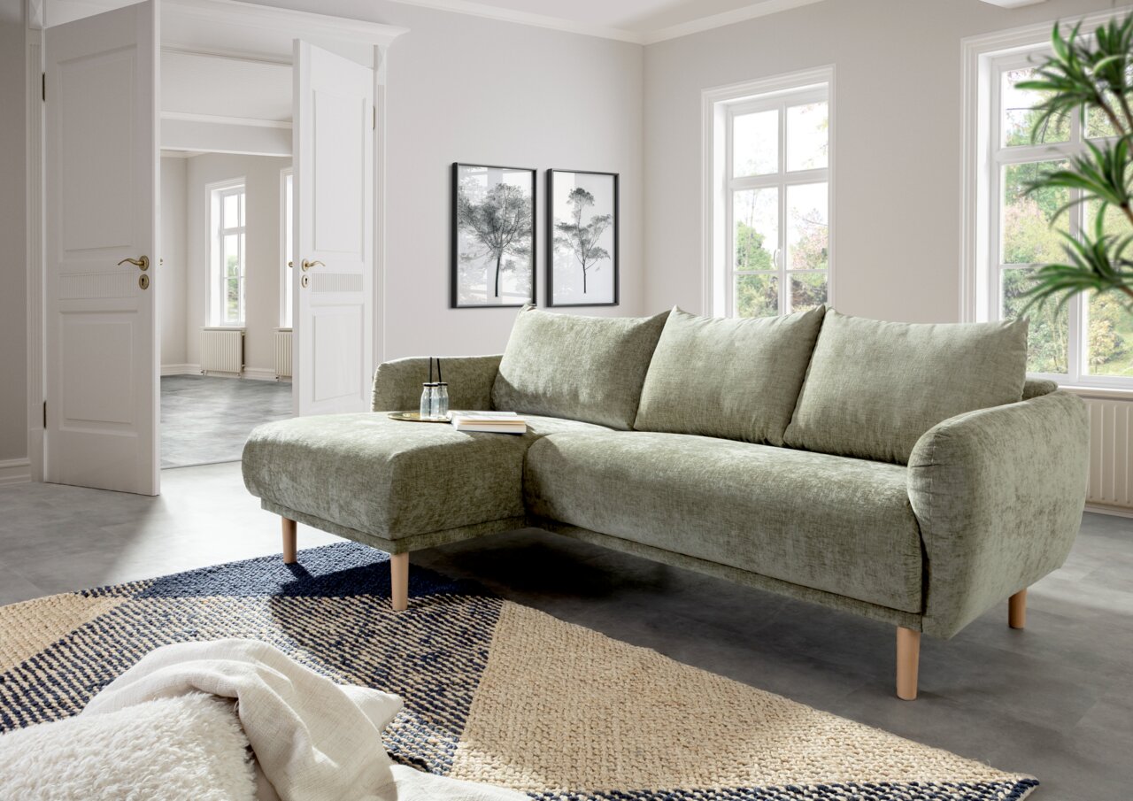 Grünes Ecksofa mit linker Ottomane in einem modernen Wohnzimmer, seitliche Perspektive