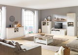 Wohnwand in einem modernen Wohnzimmer mit hellen Holzmöbeln, bestehend aus TV-Schrank, Vitrine und Regalen, aus der Perspektive eines Betrachters im Raum.