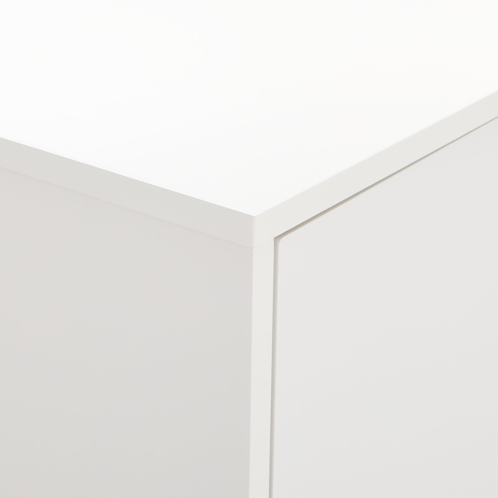 Nahaufnahme der Ecke eines weißen Highboards oder Sideboards aus der Perspektive von oben.
