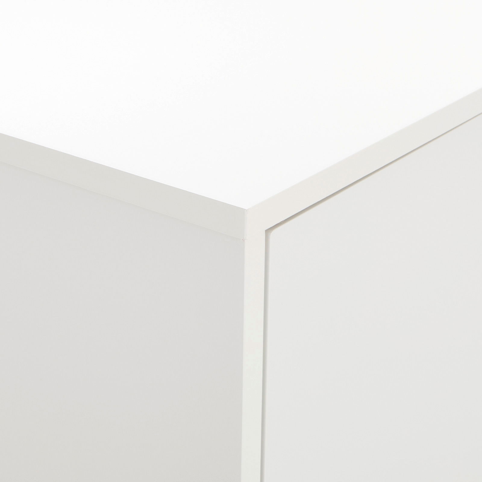 Nahaufnahme der Ecke eines weißen Highboards oder Sideboards aus der Perspektive von oben.