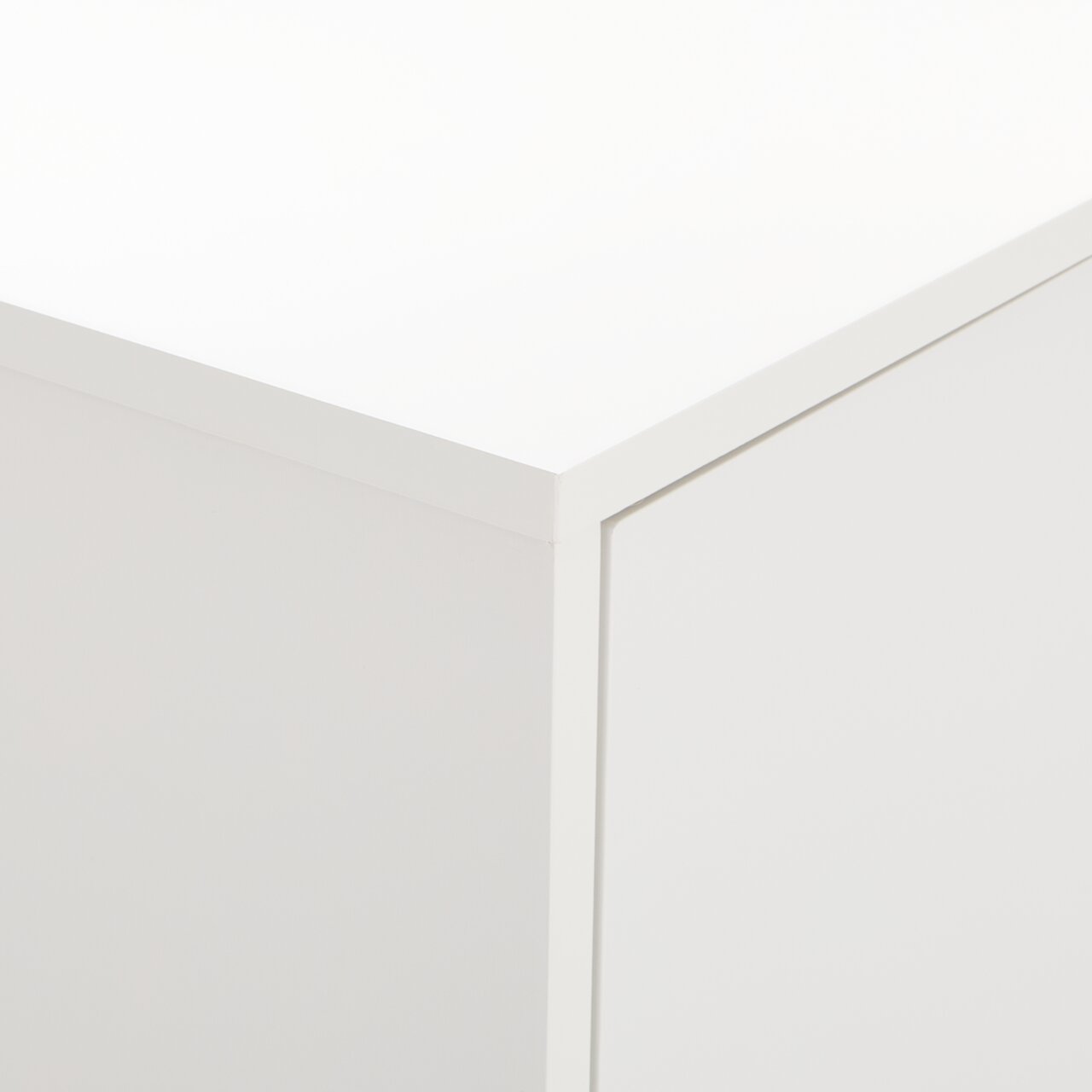 Nahaufnahme der Ecke eines weißen Highboards oder Sideboards aus der Perspektive von oben.
