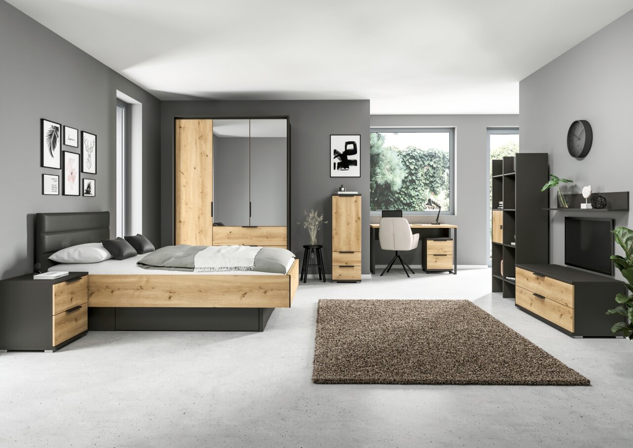 Modernes Schlafzimmer mit grauen Wänden, Holzmöbeln und einem TV-Element in der rechten Ecke, seitliche Perspektive.