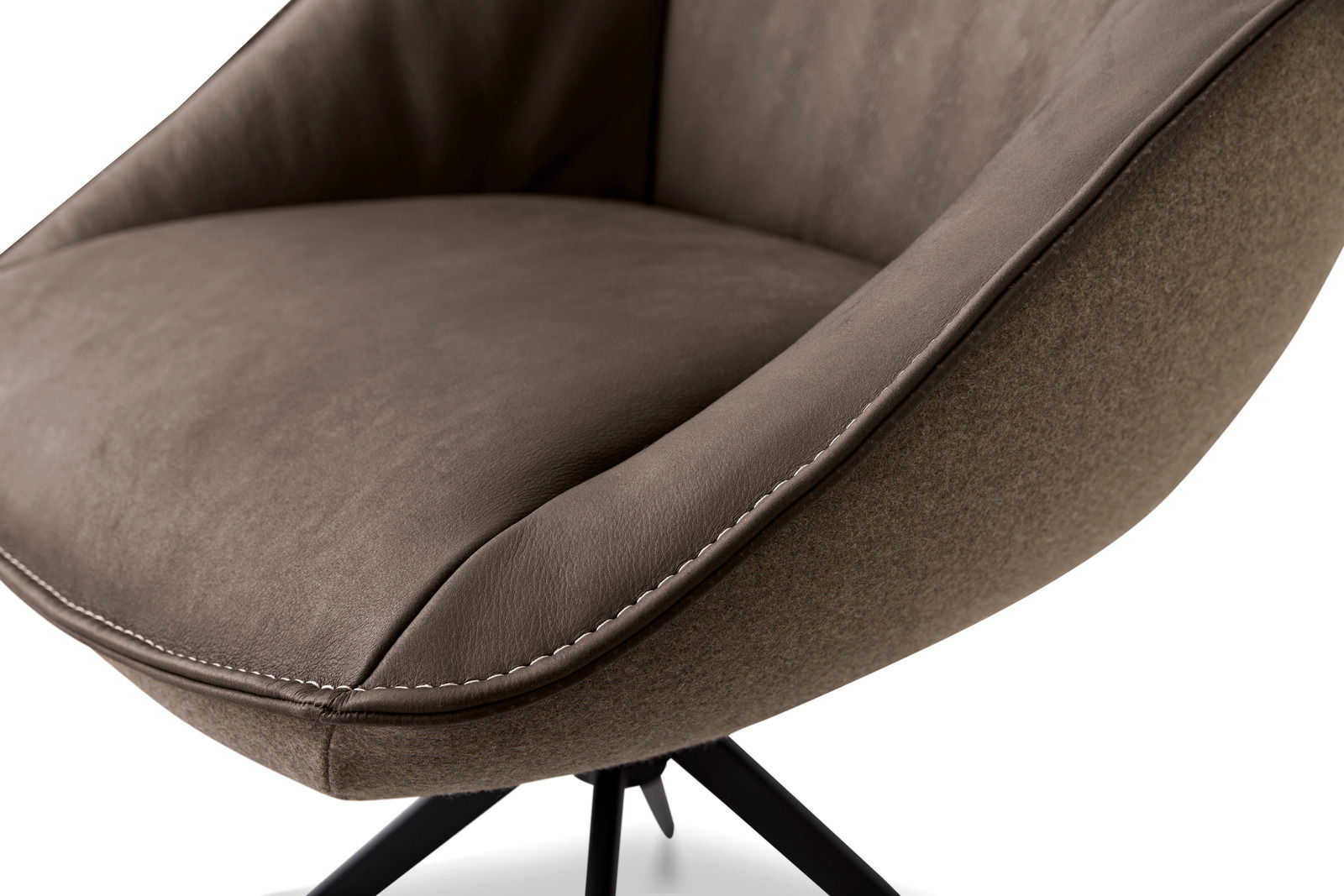 Nahaufnahme eines braunen Armlehnstuhls mit weicher Polsterung und schwarzem Metallgestell, seitliche Perspektive.