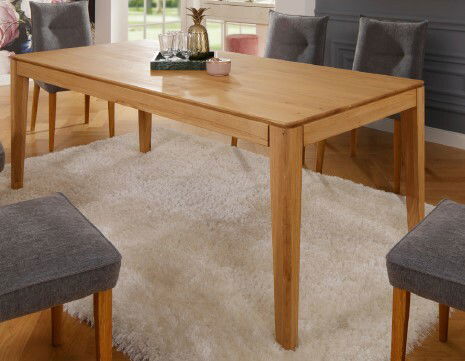 Holzesstisch 200x100 cm in einem modernen Esszimmer, aus seitlicher Perspektive fotografiert, umgeben von grauen Stühlen auf einem weißen Teppich.