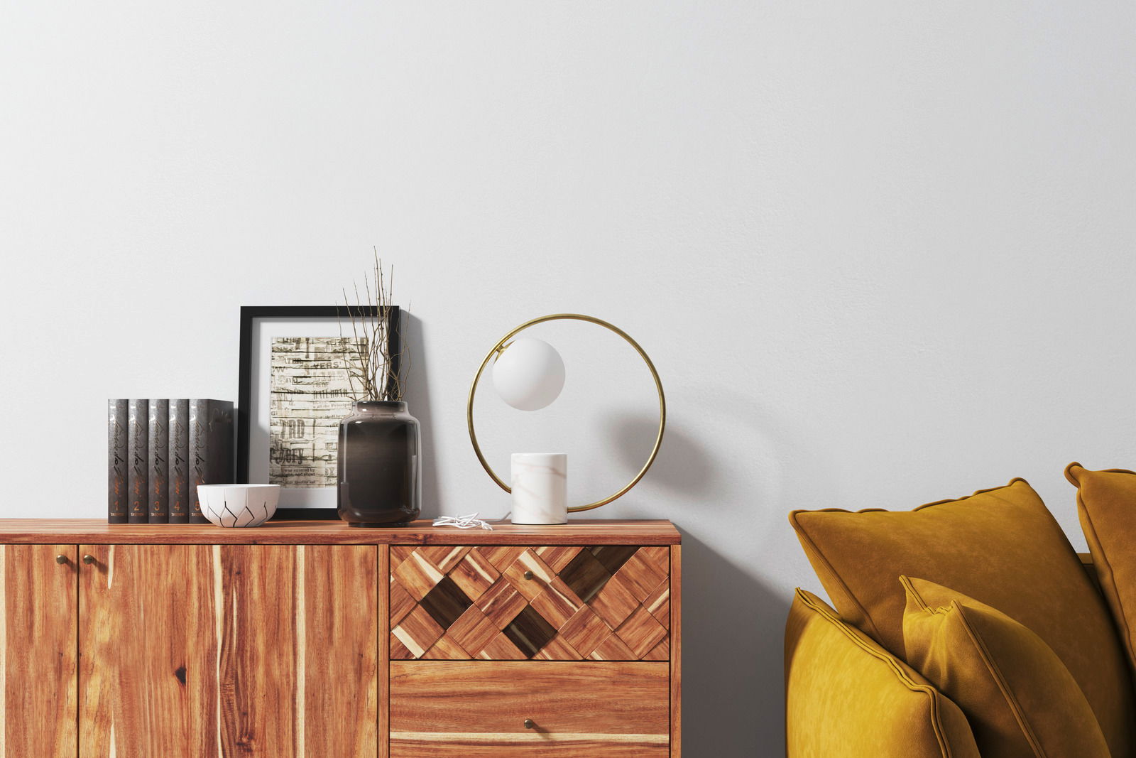 Moderne Tischleuchte Lyon mit rundem, goldenem Rahmen und weißem Leuchtkörper, seitliche Perspektive auf einem Holzschrank neben gelben Kissen.