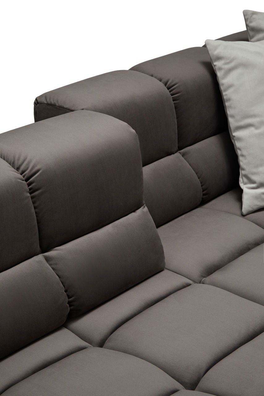 Nahaufnahme einer grauen Longchairkombination mit weichen, gepolsterten Kissen und einem modernen Design, seitliche Perspektive.