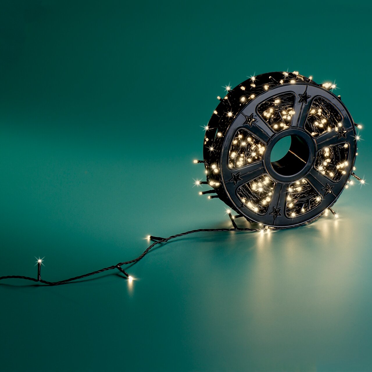 LED-Lichterkette auf einer Spule, seitliche Perspektive, leuchtend auf grünem Hintergrund