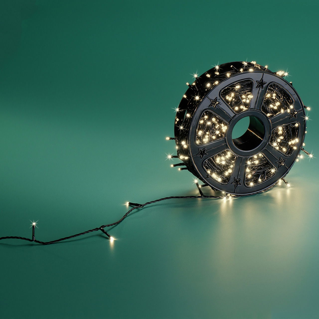 LED-Lichterkette auf einer Spule, seitliche Perspektive, leuchtend auf grünem Hintergrund