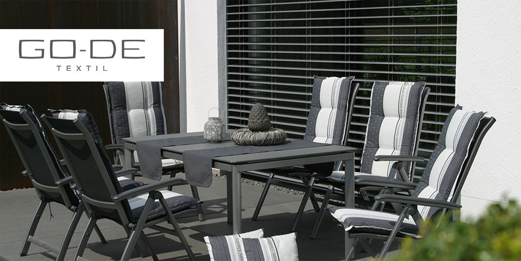 Terrasmeubilair met zwarte stoelen met gestreepte zitkussens en een tafel. Go-De-logo