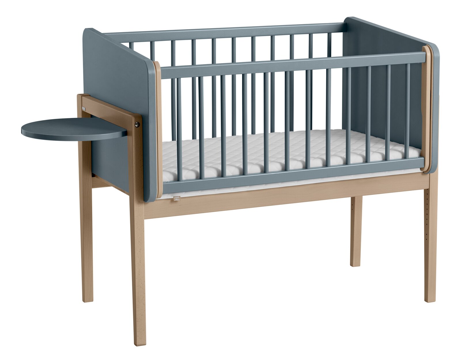 Babybedje met blauwe zijpanelen en een klein, rond tafeltje dat aan de zijkant is bevestigd, zijaanzicht