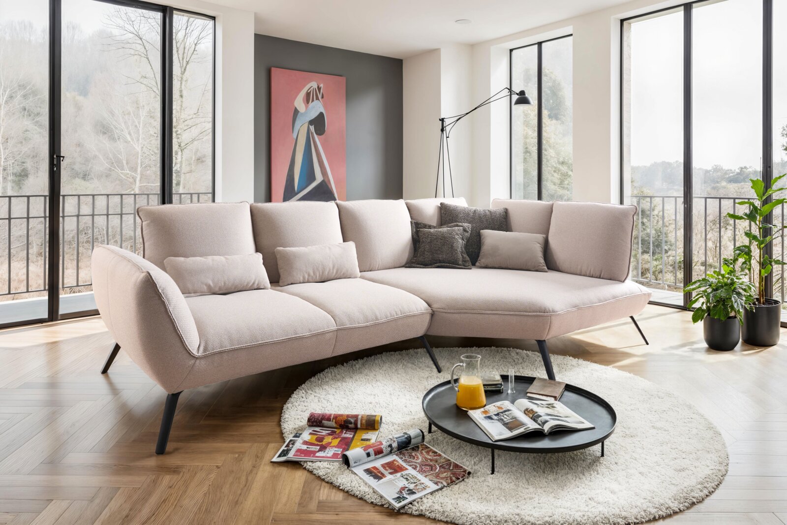 Moderne Longchairkombination in einem hellen Wohnzimmer mit großen Fenstern, aus der Perspektive von vorne links fotografiert.