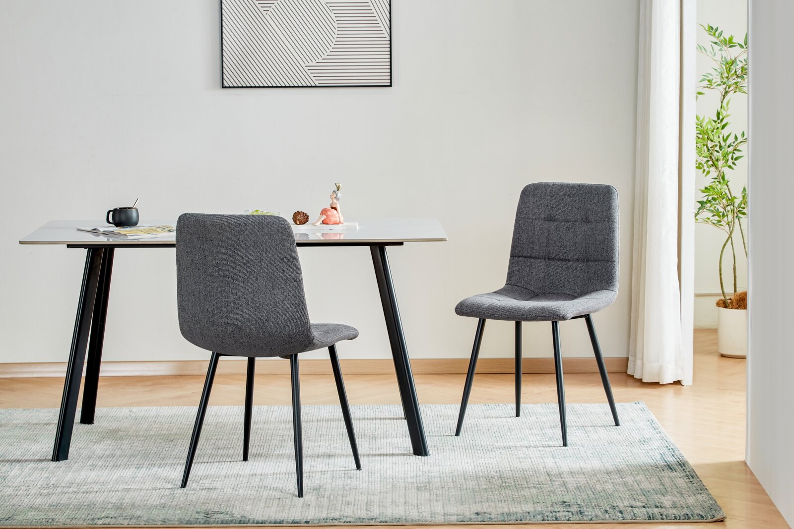 Modernes Esszimmer-Set mit weißem Tisch und zwei grauen Polsterstühlen auf Teppich, frontale Perspektive im hellen Raum