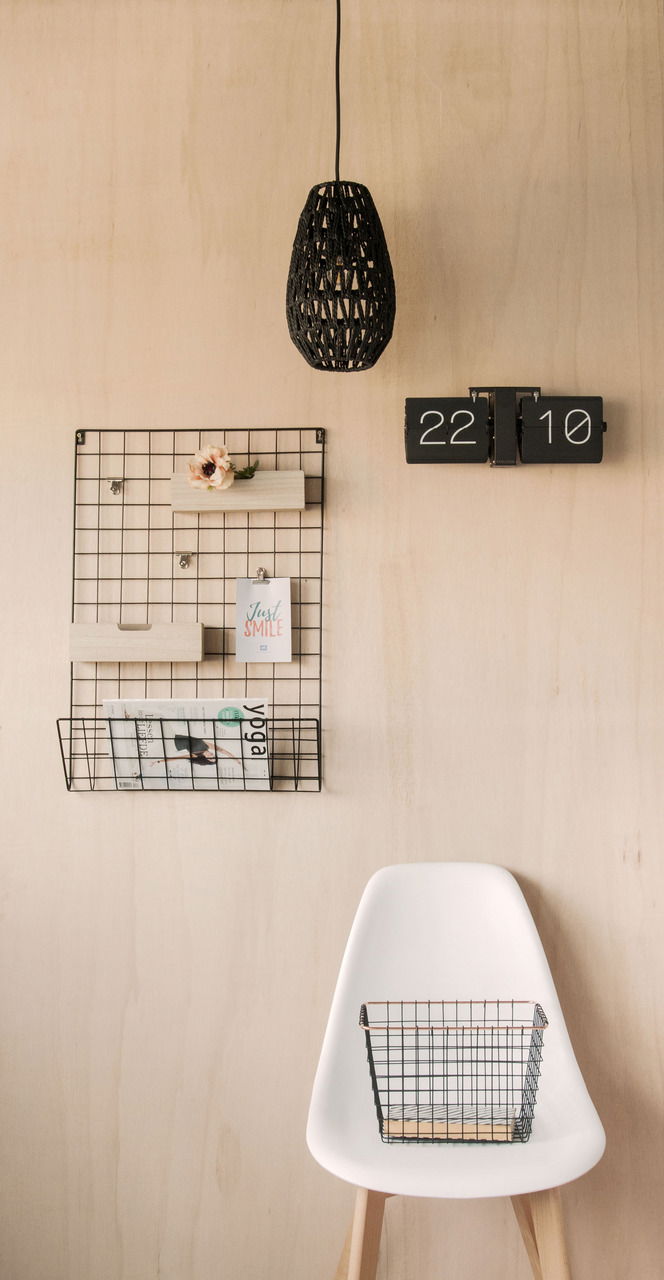Wanduhr Flip No Case in einer modernen Inneneinrichtung, frontal an einer Holzwand montiert, neben einem Drahtgitter-Organizer und einer Hängelampe.