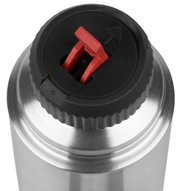 Close-up van het deksel van een roestvrijstalen thermosfles met een rode sluiting, gezien van bovenaf.