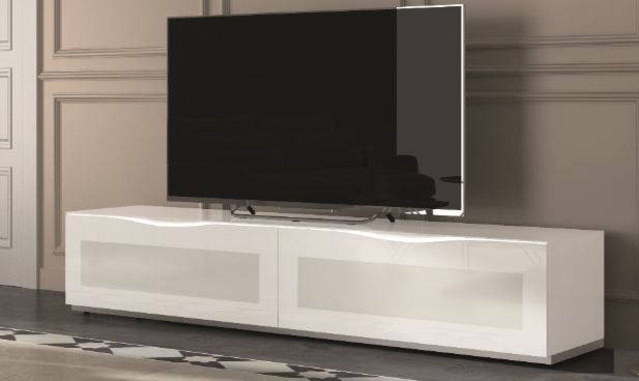 Modernes weißes TV-Lowboard mit glänzender Oberfläche, frontal betrachtet, mit großem Flachbildfernseher darauf.