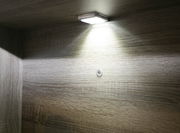 Unterbaubeleuchtung mit einem Lichtpunkt, von unten betrachtet, montiert an einer Holzoberfläche.