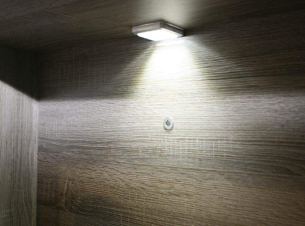 Unterbaubeleuchtung mit einem Lichtpunkt, von unten betrachtet, montiert an einer Holzoberfläche.