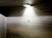 Unterbaubeleuchtung mit einem Lichtpunkt, von unten betrachtet, montiert an einer Holzoberfläche.