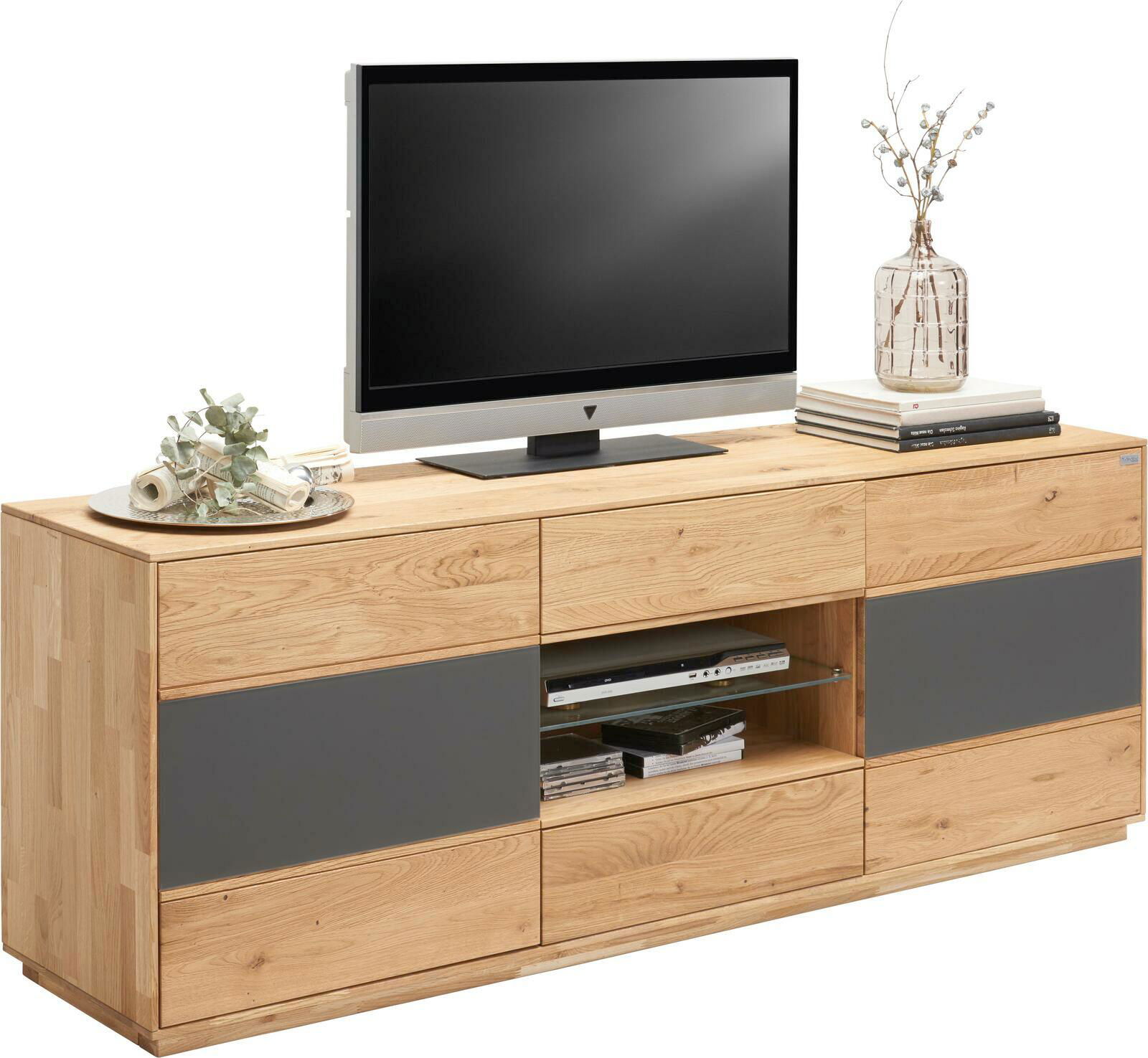 Waldwelt TV-Lowboard AVANTI TV-Lowboard aus Holz mit grauen Akzenten, darauf ein Fernseher, Dekoration und Bücher, seitliche Perspektive