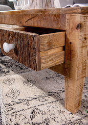 Nahaufnahme eines rustikalen Couchtisches mit geöffneter Schublade aus Holz, seitliche Perspektive
