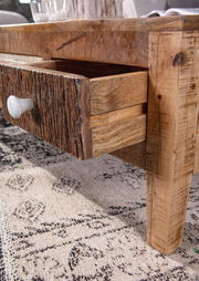 Nahaufnahme eines rustikalen Couchtisches mit geöffneter Schublade aus Holz, seitliche Perspektive