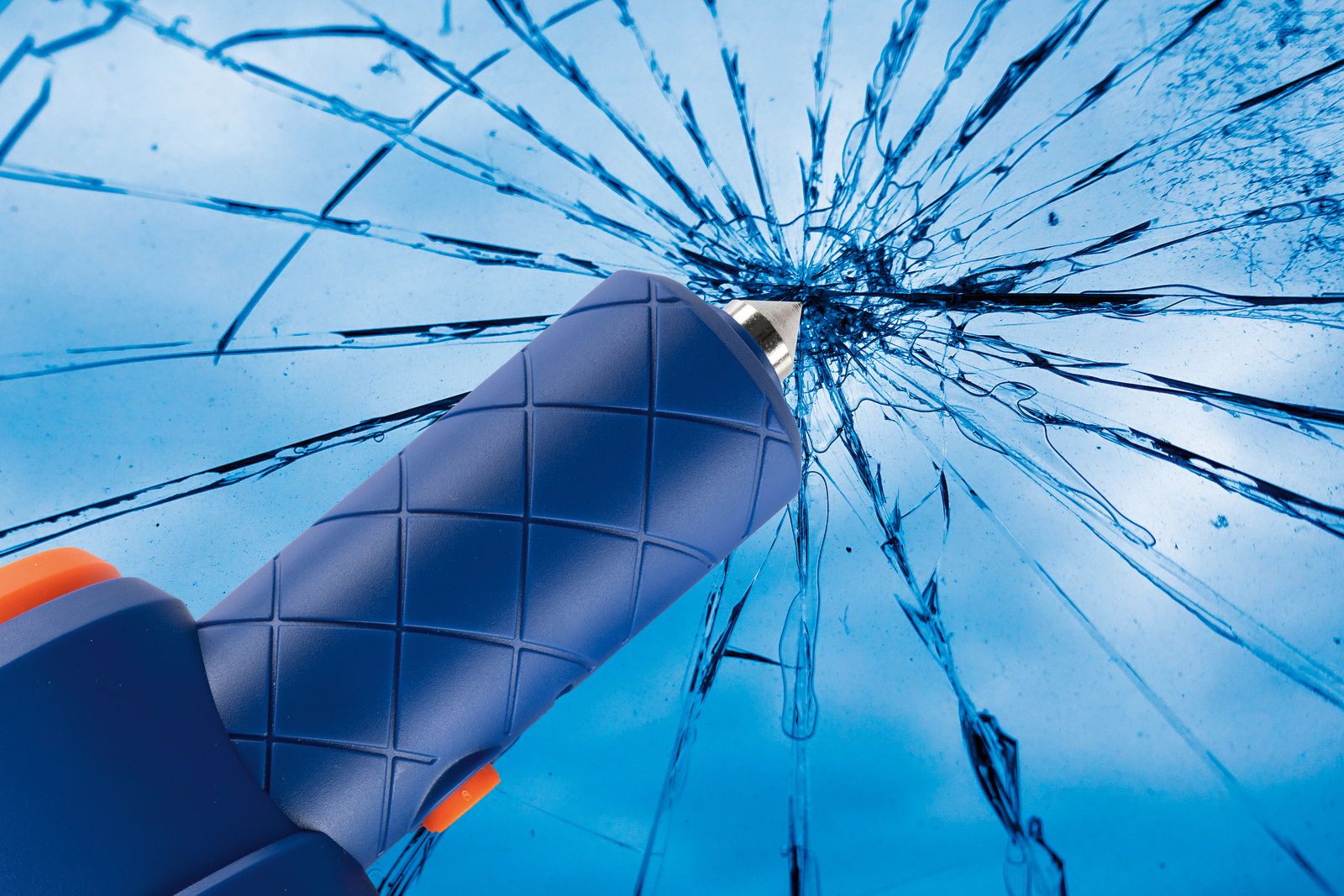 Nahaufnahme eines blauen Werkzeugs mit rutschfestem Griff, das auf eine zerbrochene Glasoberfläche zeigt.