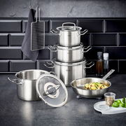 Topfset Original-Profi 5-tlg. aus Edelstahl, bestehend aus mehreren Töpfen und einer Pfanne, auf einer Küchenarbeitsplatte vor einer dunklen Fliesenwand, mit Küchenutensilien im Hintergrund.