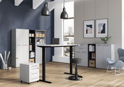 Moderne Büroumgebung mit höhenverstellbarem Schreibtisch, Rollcontainer und Aktenschränken, seitliche Perspektive