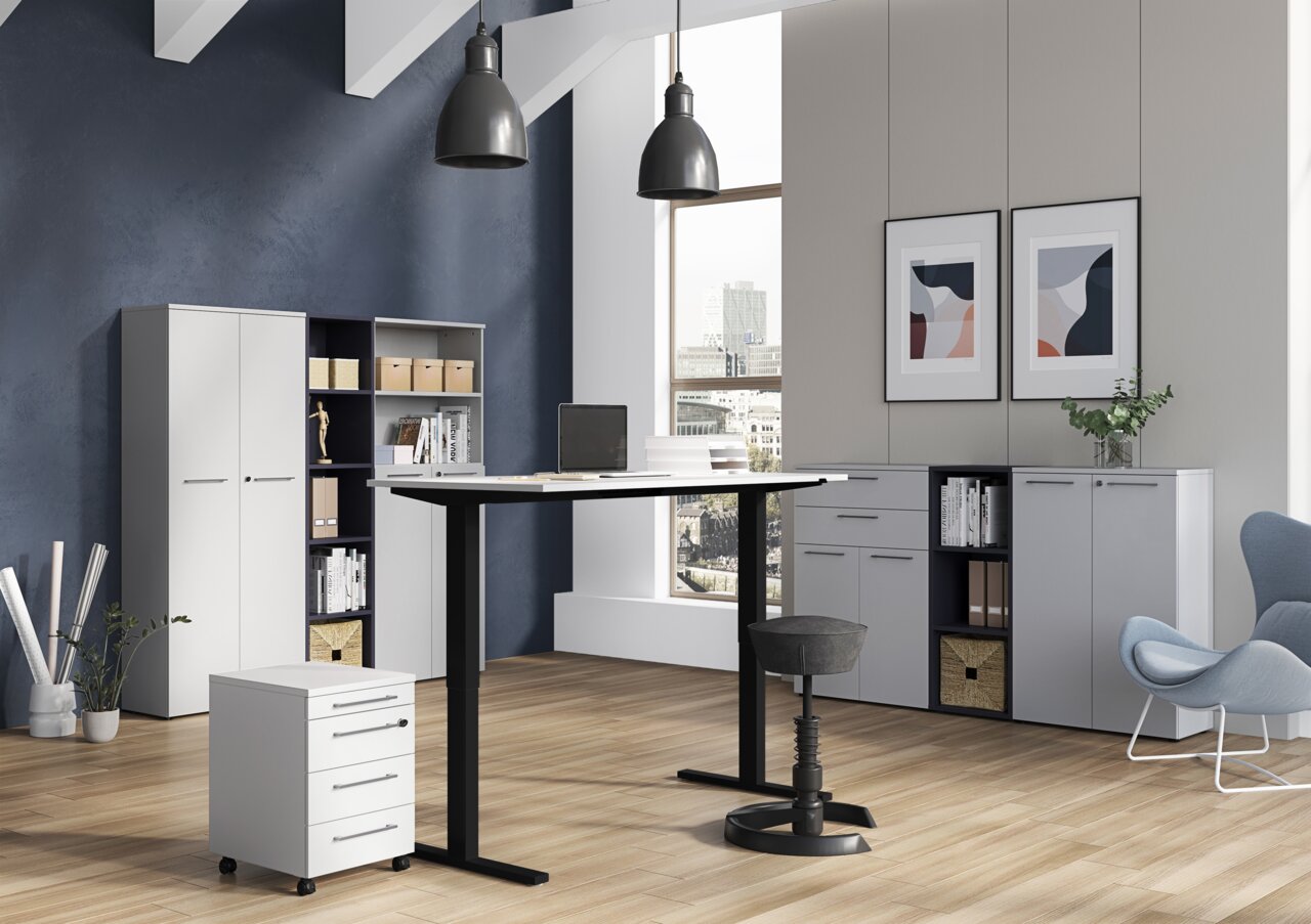 Moderne Büroumgebung mit höhenverstellbarem Schreibtisch, Rollcontainer und Aktenschränken, seitliche Perspektive