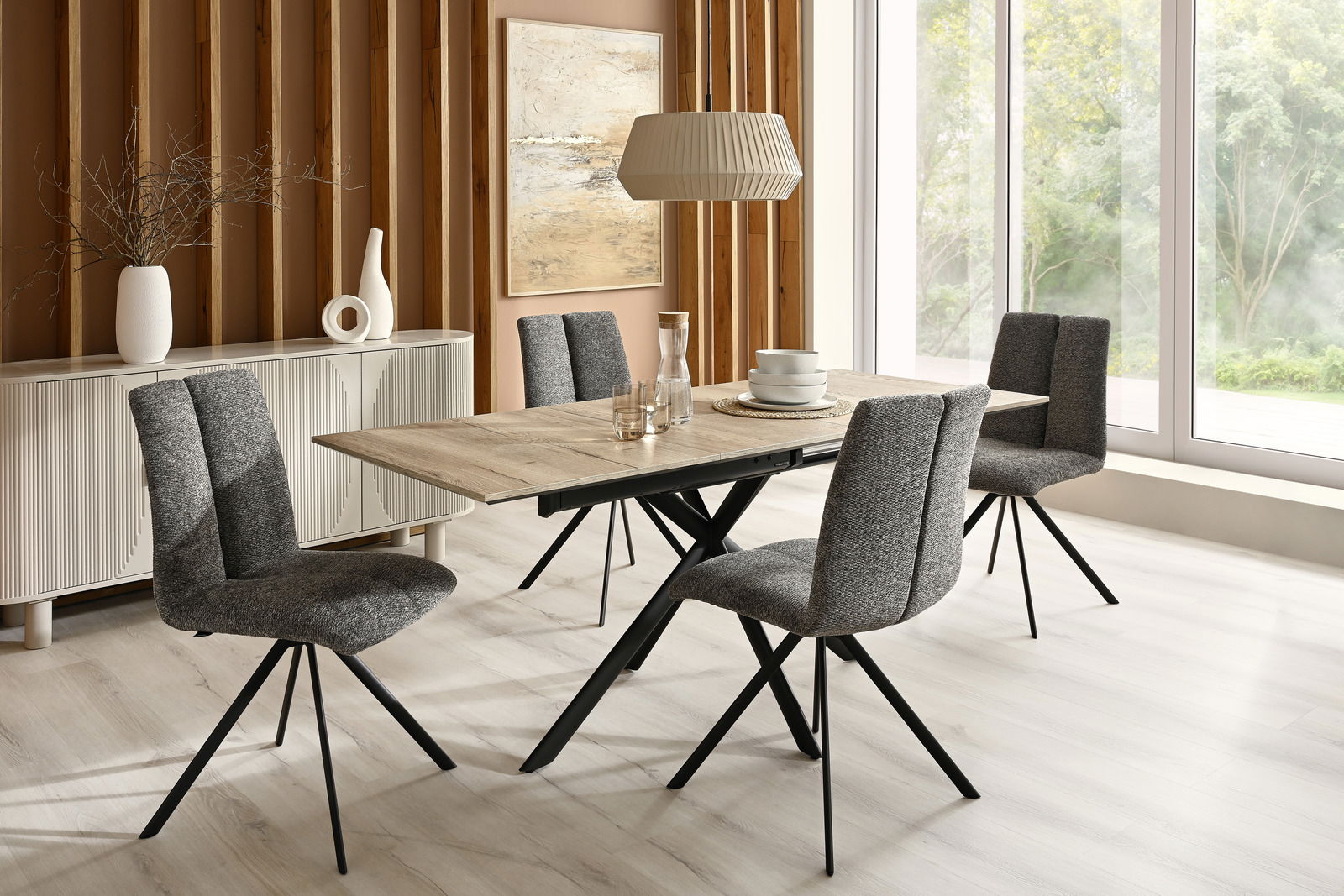Moderner Esstisch mit Holzplatte und schwarzen Metallbeinen, umgeben von vier grauen Stühlen in einem stilvollen Esszimmer mit Blick auf große Fenster.
