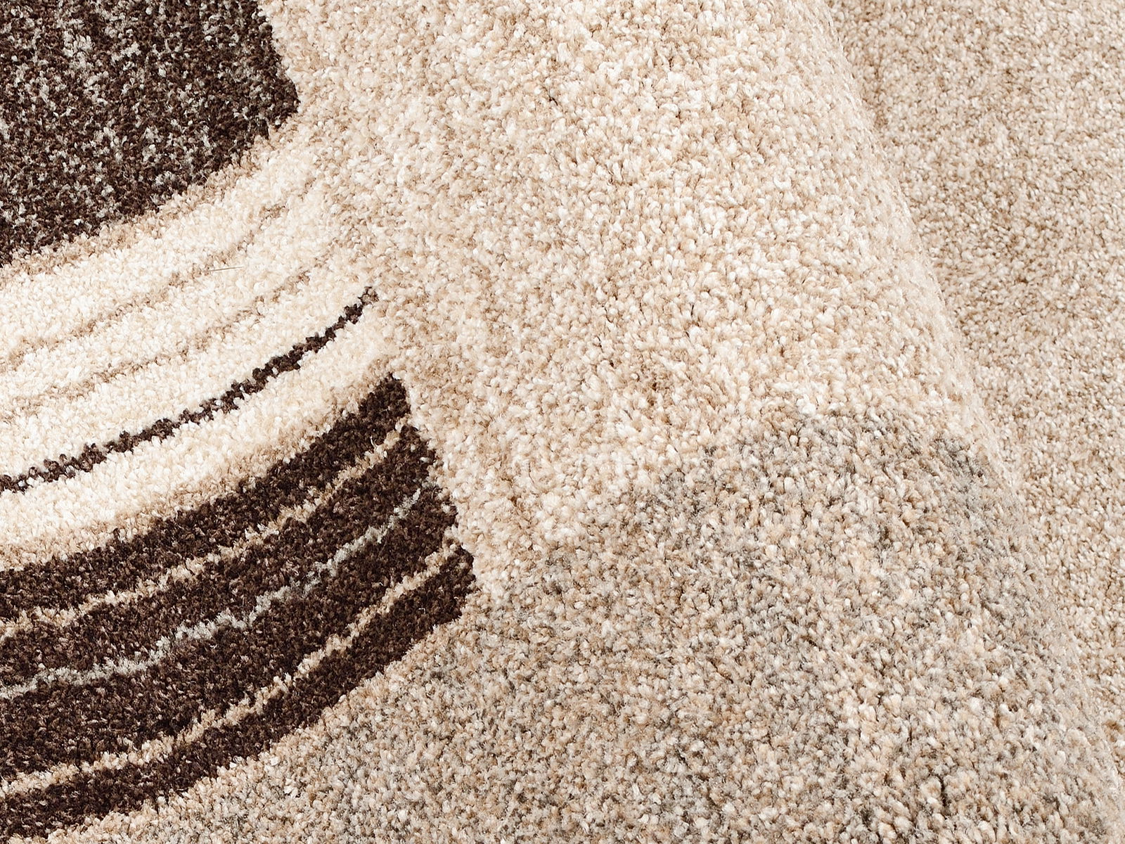 Nahaufnahme eines beigen Teppichs mit braunen Streifen, perspektivisch von der Seite aufgenommen.