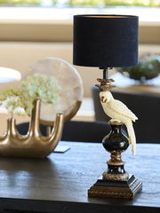 Eleganter Lampenschirm Zylinder mit schwarzem Stoff und dekorativem Papageienfuß, seitliche Perspektive auf einem Tisch.